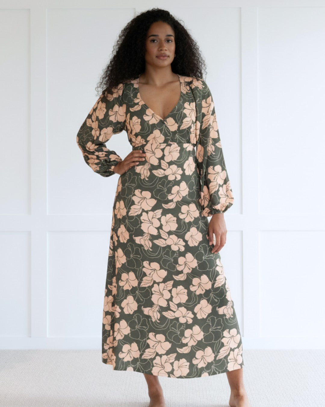 Woman wearing a floral island dress with a plain background