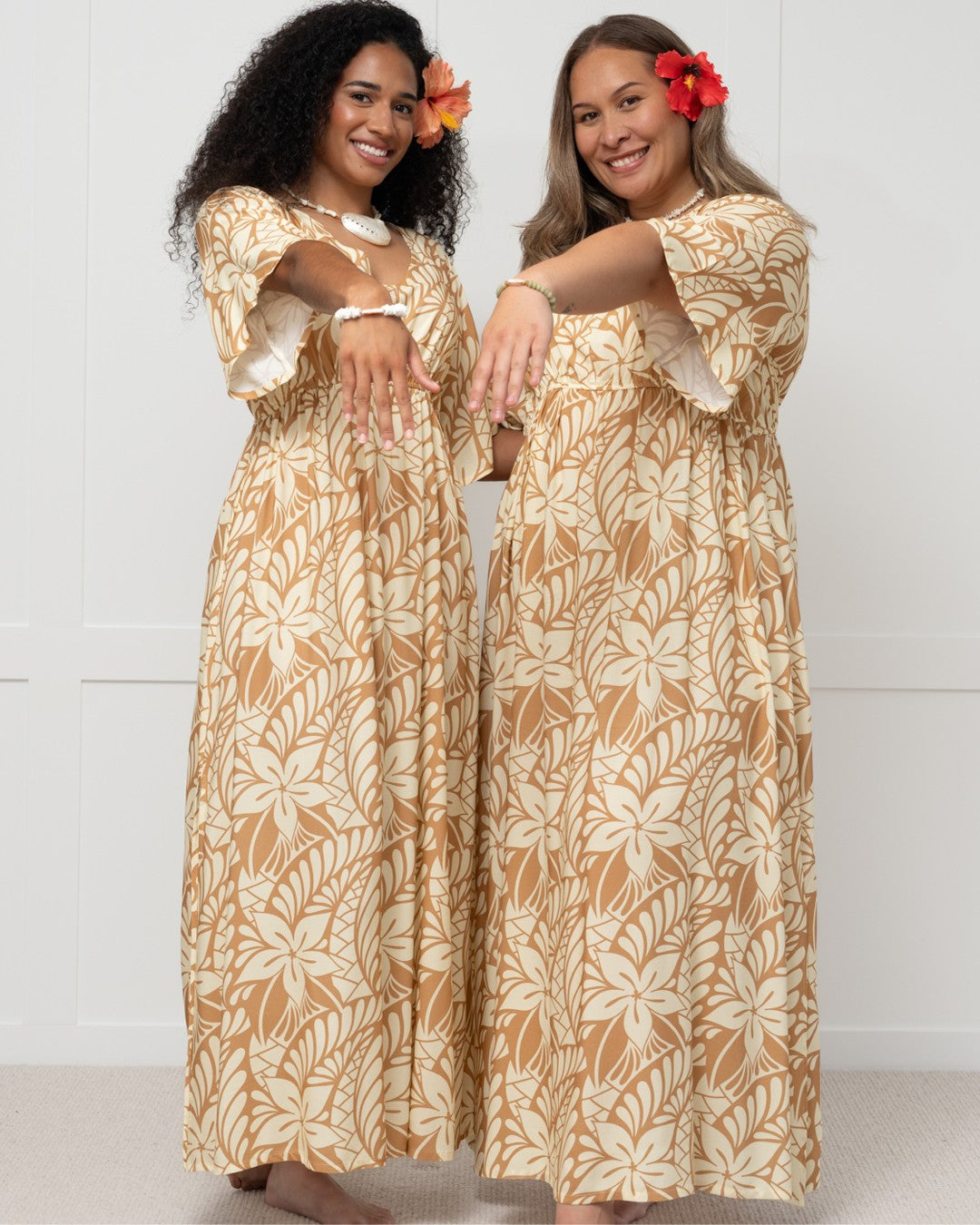 Woman wearing a long, patterned island dress against a white background