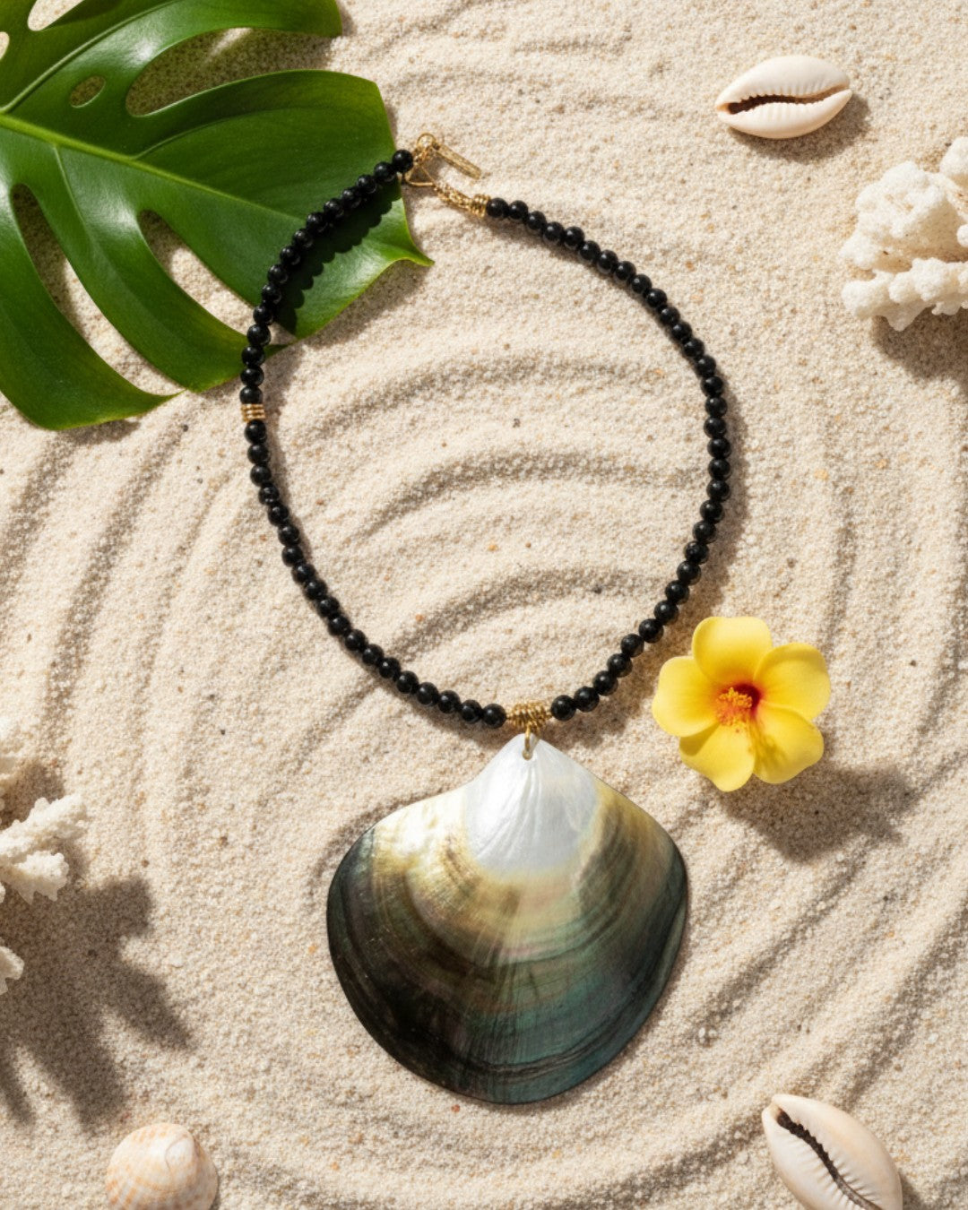 Woman wearing a large shell pendant necklace with a blurred beach background
