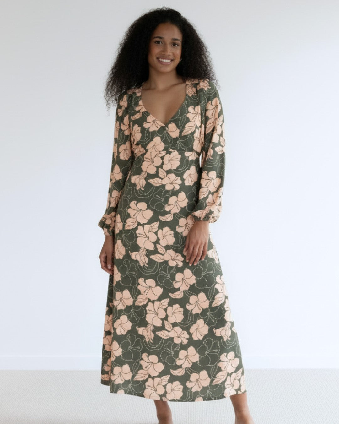 Woman wearing a floral island dress with a plain background