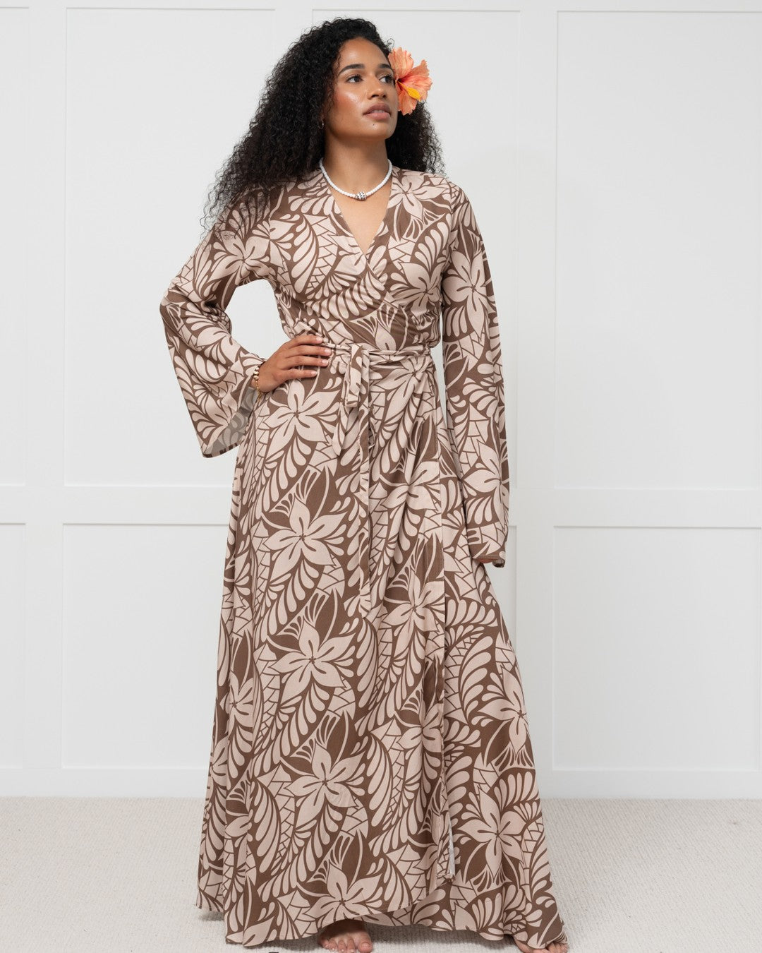 Woman wearing a long floral dress against a white background