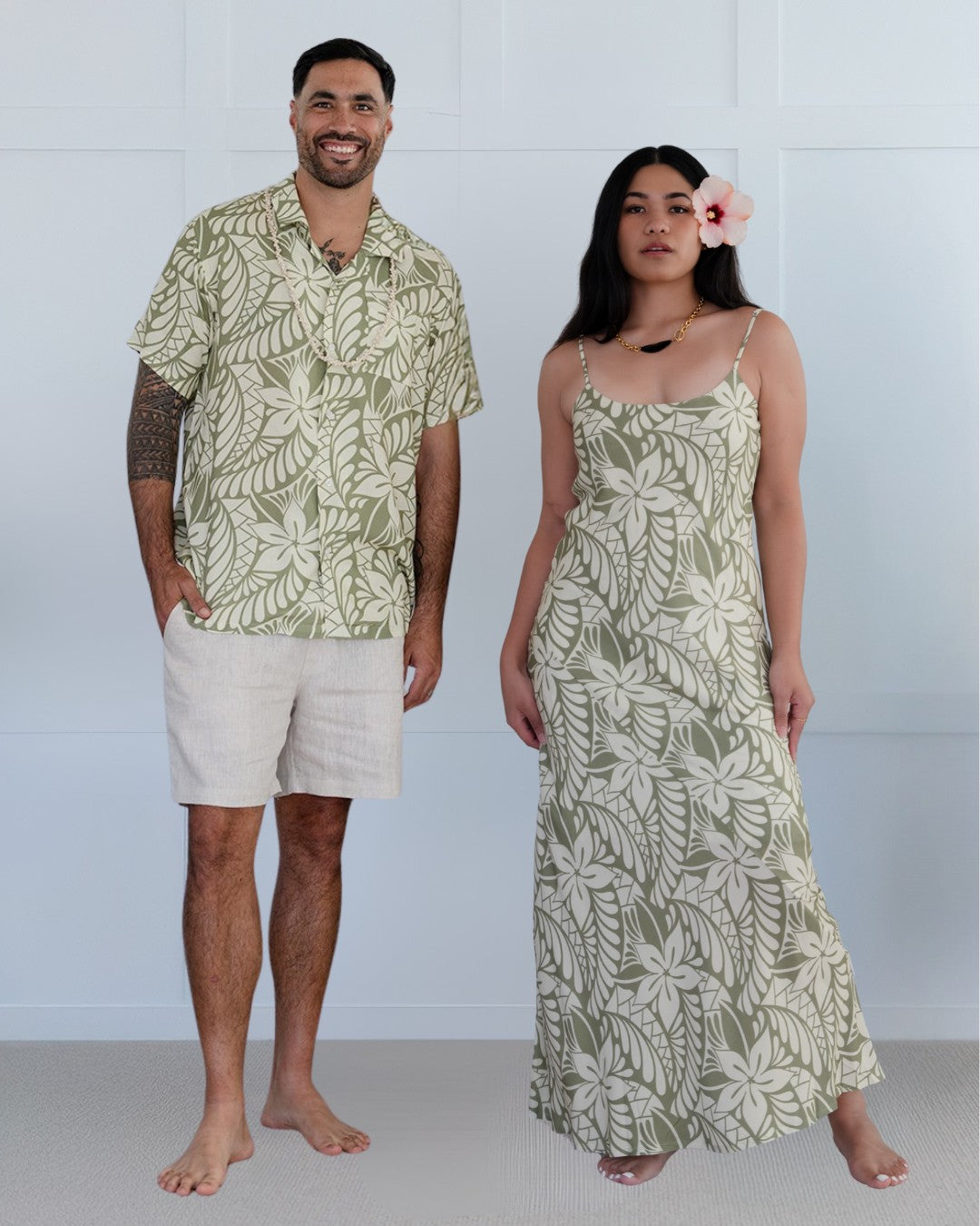 Man and woman wearing matching island style patterned outfits against a white background