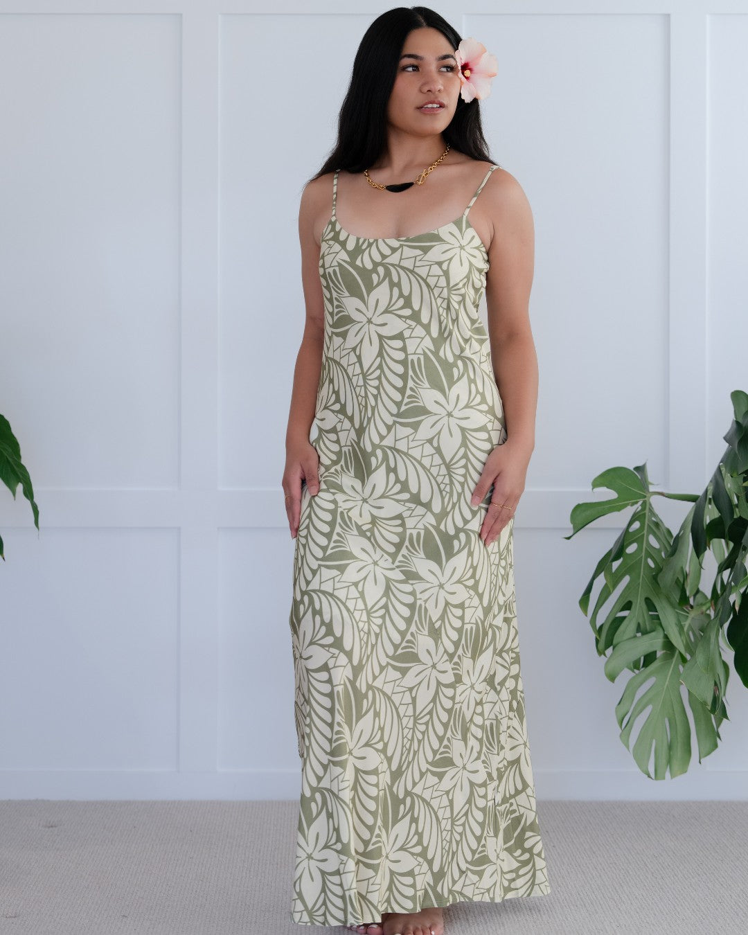 Man and woman wearing matching island style patterned outfits against a white background