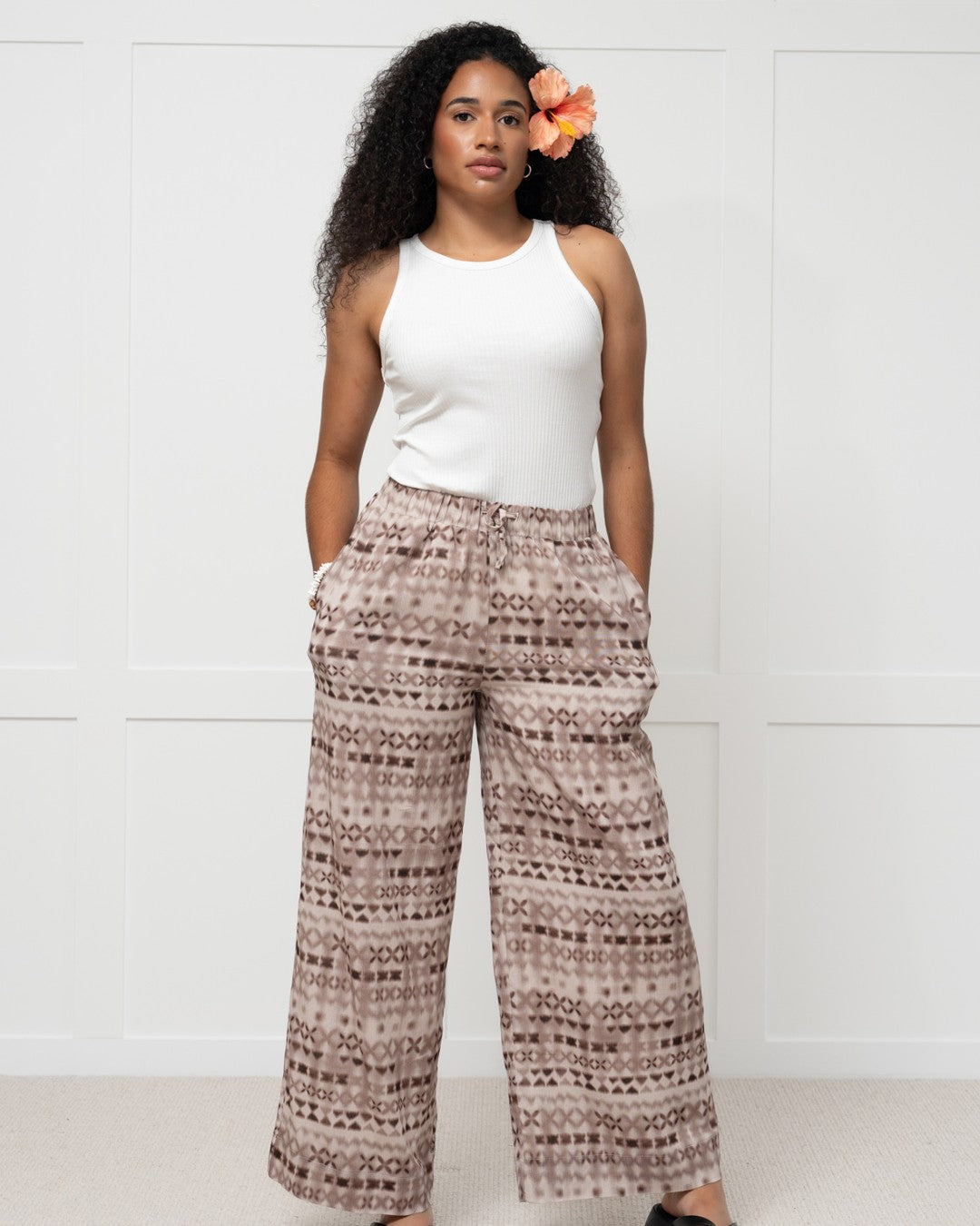 Womens against white wall in pacific motif island fashion pants