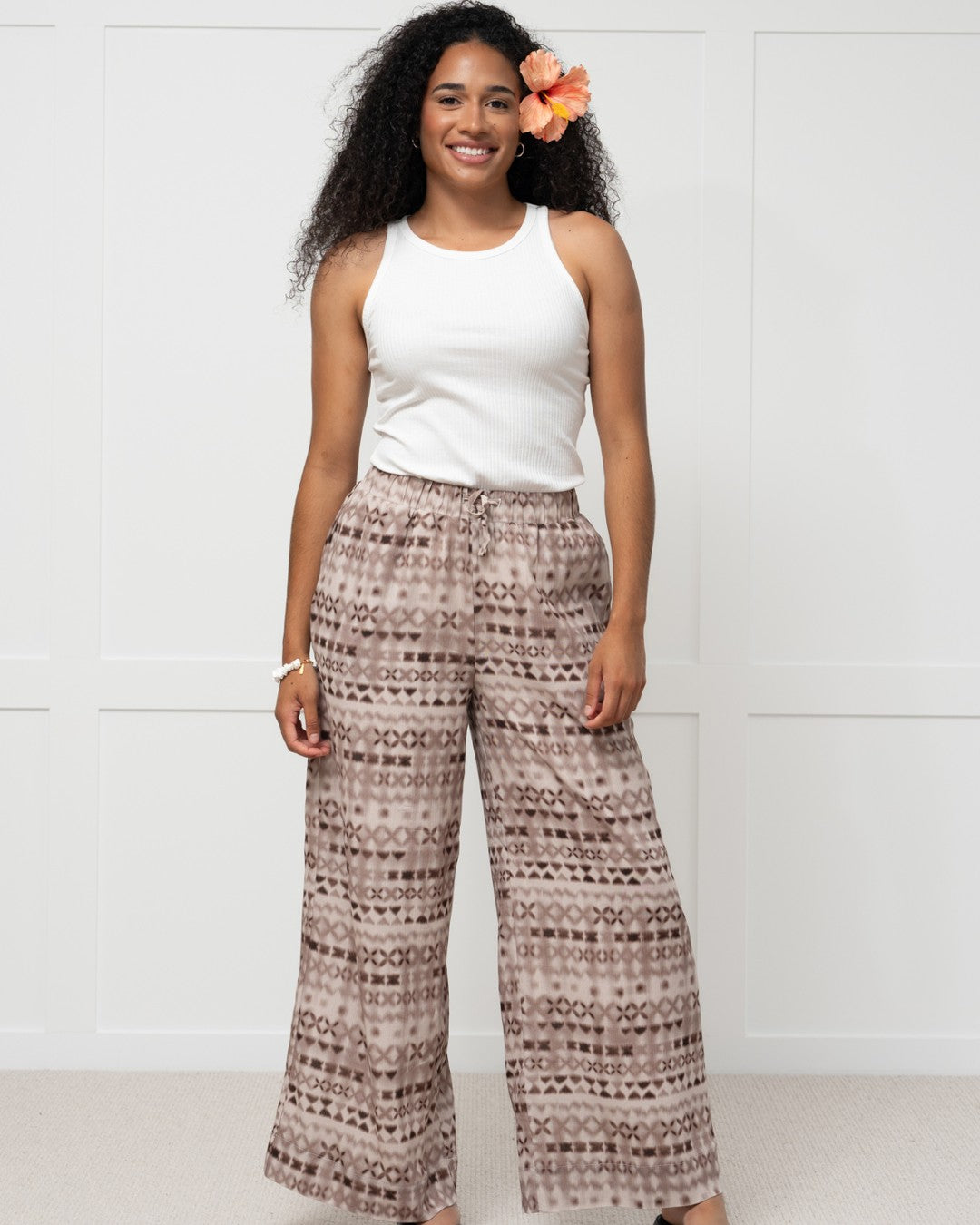 Womens against white wall in pacific motif island fashion pants