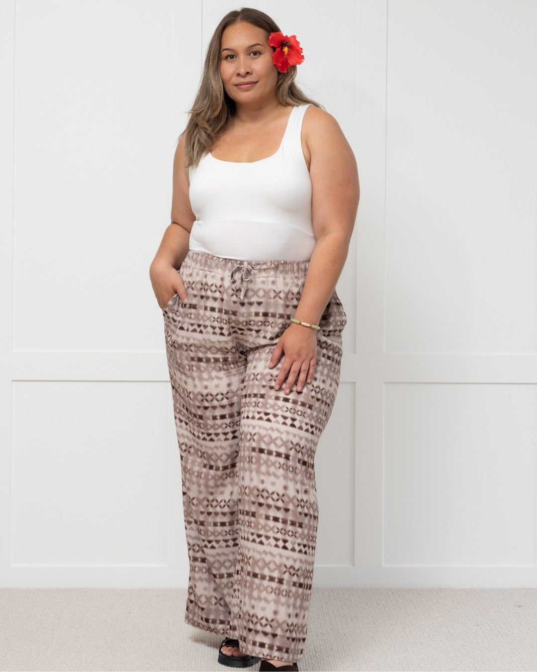 Womens against white wall in pacific motif island fashion pants